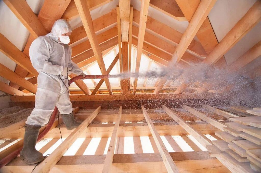 Technician blowing insulation in attic